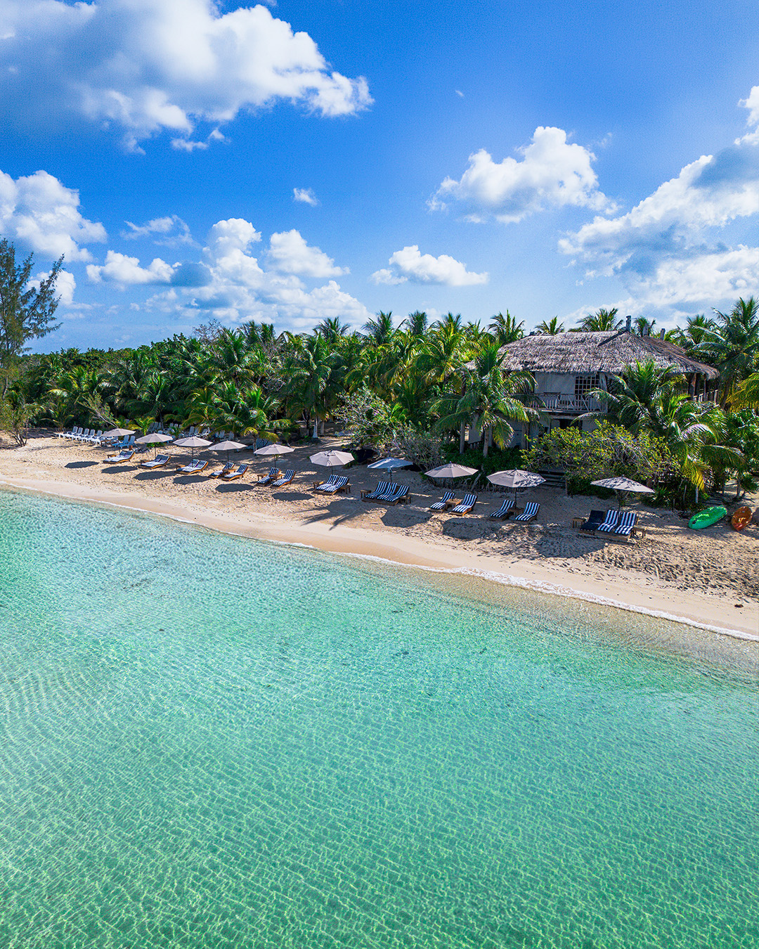 Aerial view of a private Cozumel beach club with loungers, umbrellas and turquoise water